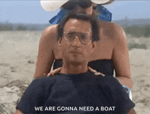 a man is sitting on a beach with a woman behind him .