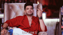 a man in a red shirt is sitting in a chair with gaya kaar se written on the bottom right