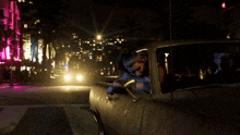 a woman is sitting in a car with her head out the window at night