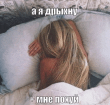 a woman with long blonde hair is laying in bed with a pillow and a caption in russian