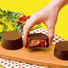 a person is taking a piece of chocolate with strawberries inside of it