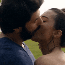 a man and a woman are kissing and the woman is wearing earrings