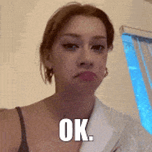 a woman in a bathrobe is making a funny face and says ok