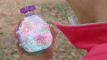 a person in a pink jacket is holding a bottle that says jelly on it