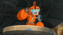 an orange robot with blue eyes is sitting on top of a round object