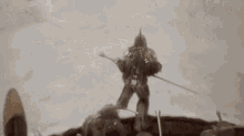 a group of people are standing in the snow holding sticks and a sword .
