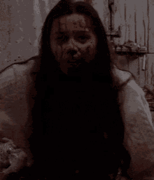 a woman with blood on her face is sitting in a chair