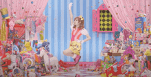 a girl in a pink and yellow outfit stands in a room filled with toys