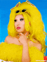 a woman with bright yellow hair is wearing sunglasses and earrings