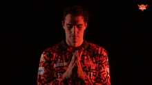 a man wearing a kent shirt with his hands folded