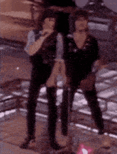 two men are standing next to each other on a stage .