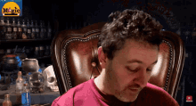 a man sits in a chair in front of a screen that says magic on it
