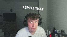 a man wearing headphones with the words i smell that behind him