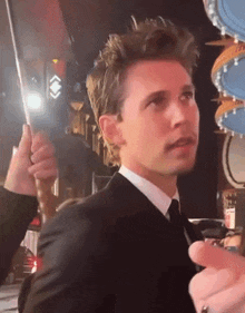 a man in a suit and tie is holding an umbrella in his hand