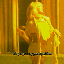 a woman in a yellow dress is standing in front of a door with the words did you just say you 're finished