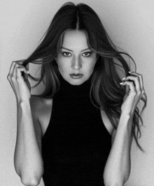 a black and white photo of a woman in a black top