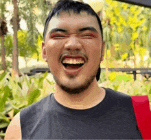 a man with a beard is laughing with his eyes closed
