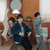a group of young men are dancing in front of a wall with a poster that says canada on it