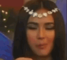 a close up of a woman wearing a flower crown on her head
