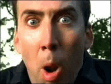 a close up of a man 's face with a surprised look on his face