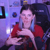 a girl with a bowl of food on her face is wearing a red shirt with the number 0 on it