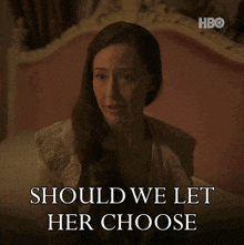 a woman sitting on a bed with the words should we let her choose behind her