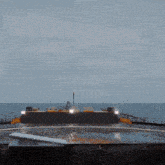 a large ship is in the middle of the ocean with a few lights on the side
