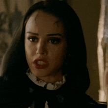 a close up of a woman 's face with blood on her forehead