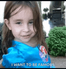 a little girl is wearing a blue dress and says i want to be famous