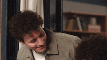 a man with curly hair stands next to a woman with curly hair