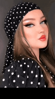a woman wearing a black and white polka dot bandana