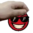a hand is touching a red smiley face with sunglasses on .