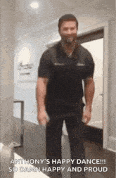 a man in a black shirt is standing in a hallway holding a bottle of beer .