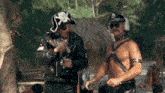 a man wearing a pirate hat and headphones is standing next to another man