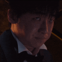 a man in a tuxedo and bow tie looks up at something