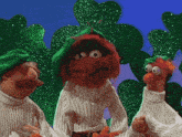 three muppets wearing white sweaters and green beret