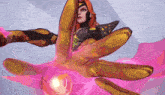 a woman in a superhero costume is holding a pink object in her hand