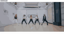 a group of women are dancing in front of a sign that says wne