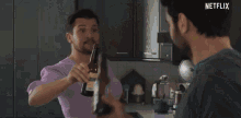 a man with a beard is looking at himself in a mirror while holding a knife .