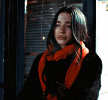a woman wearing a scarf and a fur coat smoking a cigarette