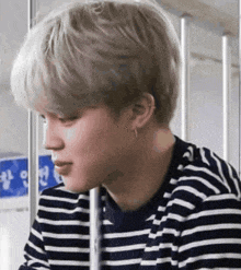 a close up of a person wearing a striped shirt and earring .