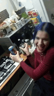 a woman with blue hair is smiling and holding a can of pepsi
