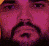 a close up of a man 's face with a beard