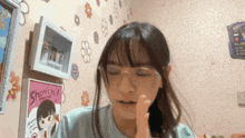a girl wearing glasses is sitting in front of a poster that says shonichii