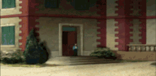 a man in a blue shirt stands in front of a building