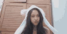 a young girl wearing a white bunny hat making a funny face .