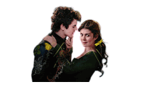a man kisses a woman on the forehead while she holds a flower in her hair