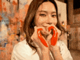 a woman making a heart shape with her hands .