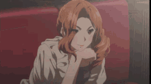a woman with brown hair is sitting on a red couch with her eyes closed