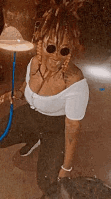 a woman with dreadlocks is smoking a hookah in a dark room .